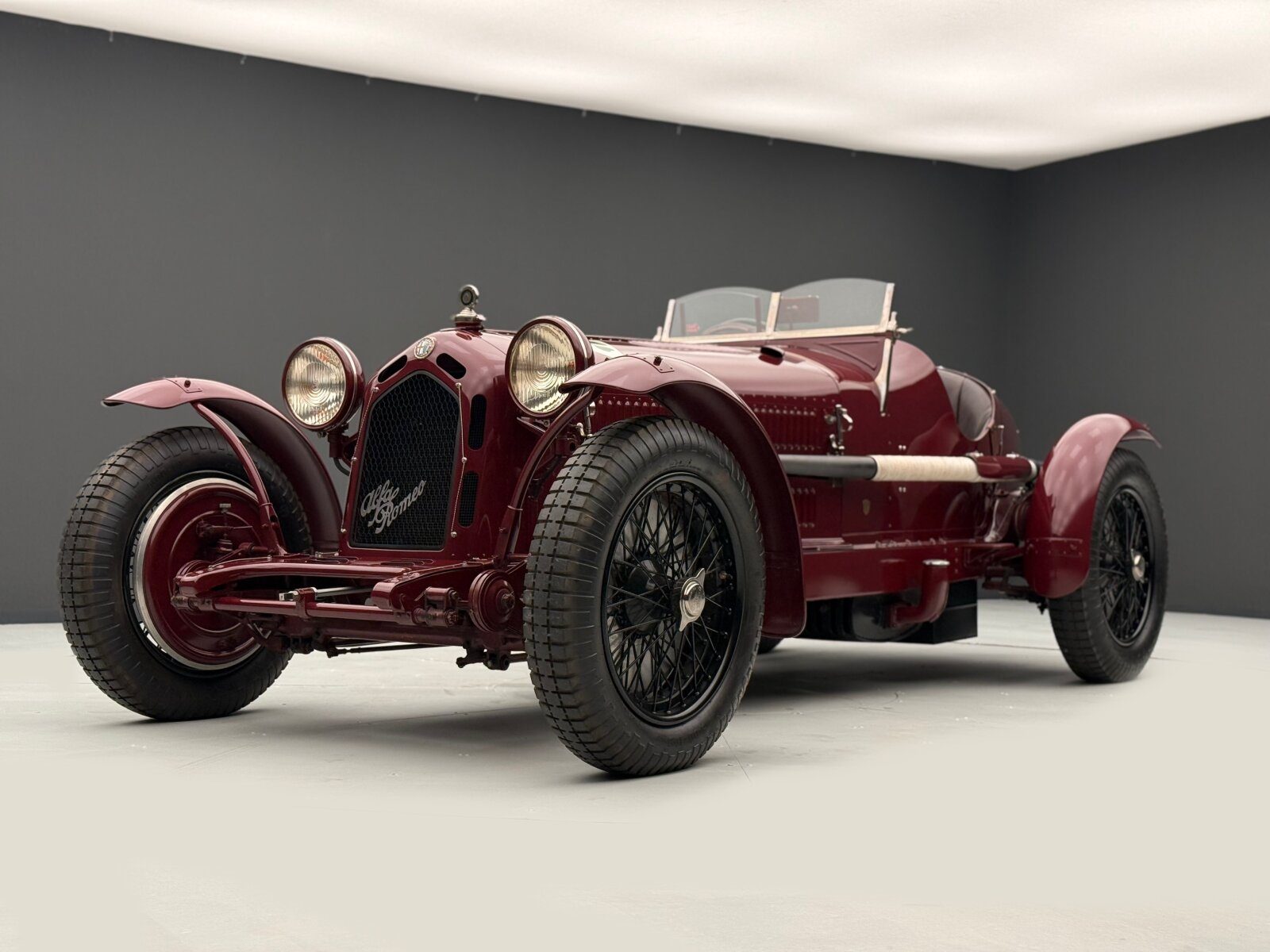 Alfa Romeo 8C in Dunkelrot, freigestellt vor grauem Studiohintergrund